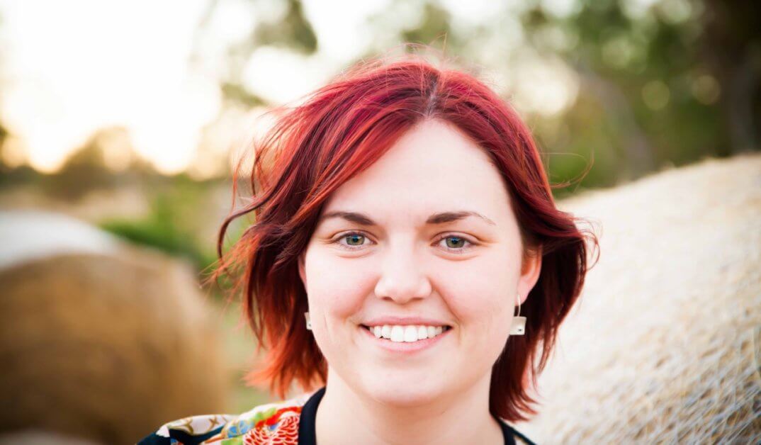 Sarah Elliott Woman with red hair smiling at camera